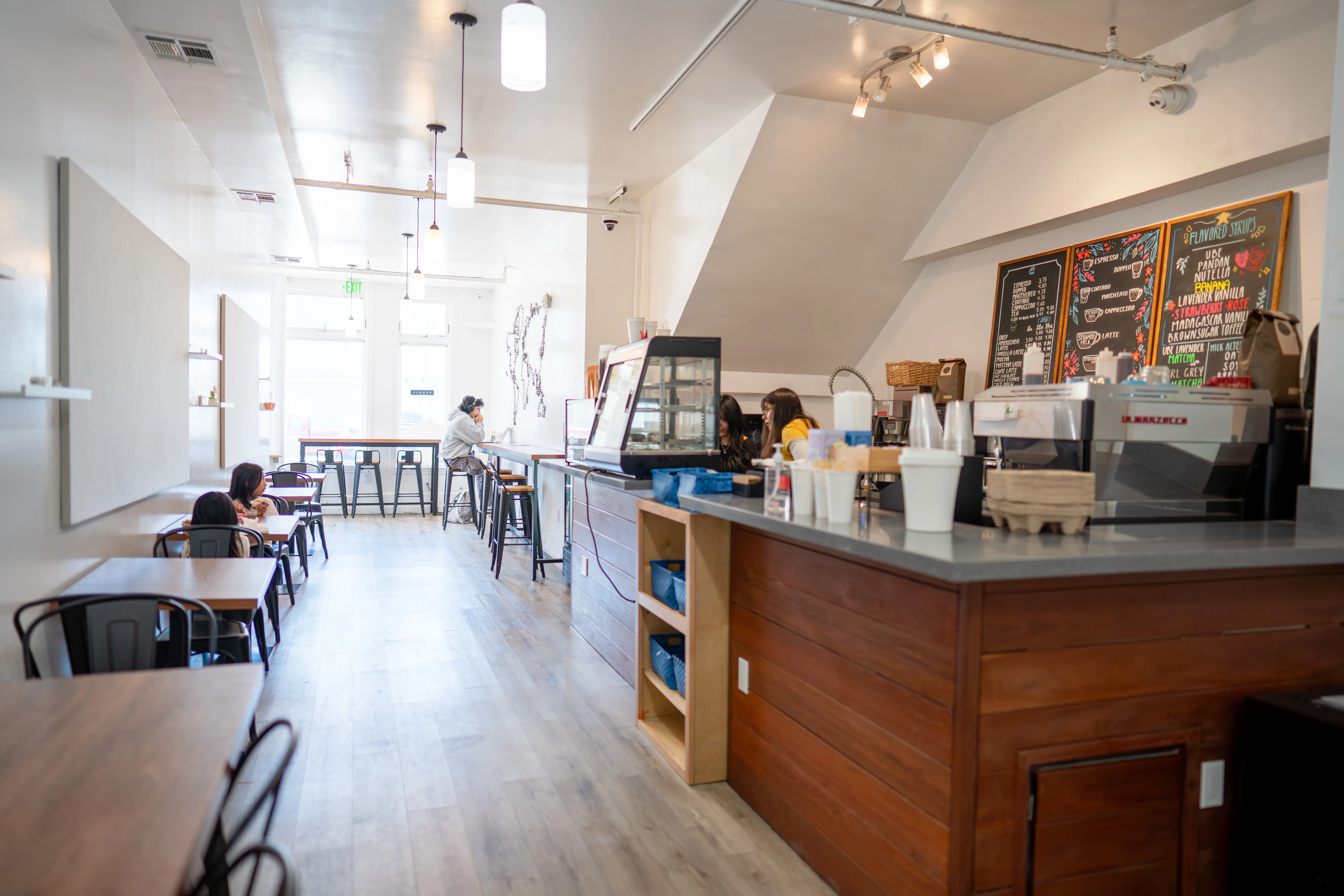Inside Blue House Cafe — the espresso bar and counter seating, lit by morning light from the front windows.