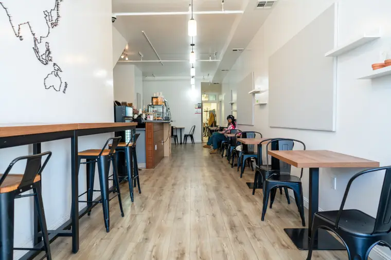 The dining room at Blue House Cafe — a hand-drawn world map on the wall above counter seating.